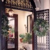 A beautifully-designed gated entryway decorated with different small potted plants